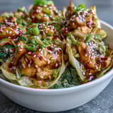 A close-up of vibrant Egg Roll Bowls with Chicken and Cabbage, showcasing juicy chicken and shredded vegetables tossed in a glossy sesame-soy glaze.