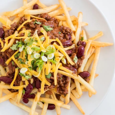 Golden fries smothered in homemade kidney bean chili and bubbling cheddar, finished with cilantro for color.