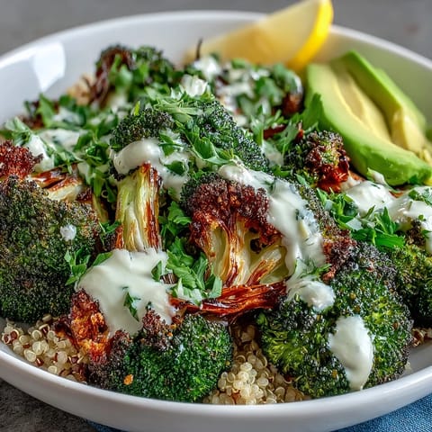 A close-up view shows crispy roasted broccoli florets and sliced avocado in a Roasted Broccoli Bowl, ready to be mixed with savory grains and sesame seeds.  