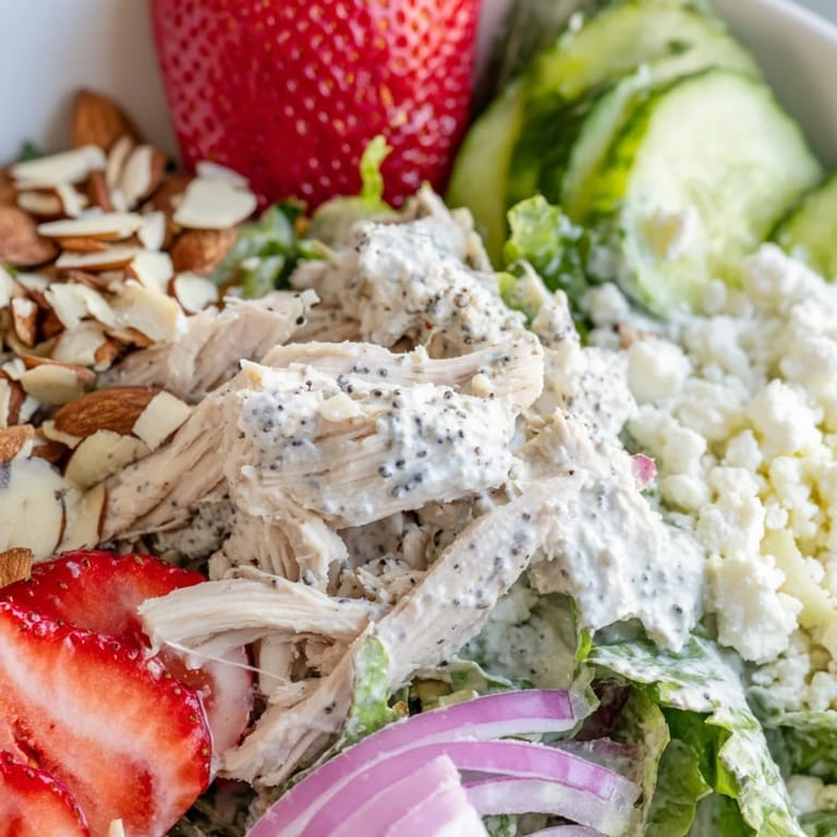 Juicy strawberries and shredded chicken tossed in a honey poppy seed dressing, finished with crunchy almonds on a bright summer salad.