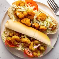 Crispy Cajun fried shrimp on a soft French roll, loaded with lettuce, tomato, and creamy mayonnaise.