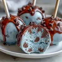 Bite-sized robins egg blue cake pops with speckled chocolate coating, perfect for festive spring dessert tables.  